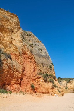 Praia Dona Ana Lagos, Algarve, Portekiz 'de güzel bir sahil kenarında beyaz bir iskele.