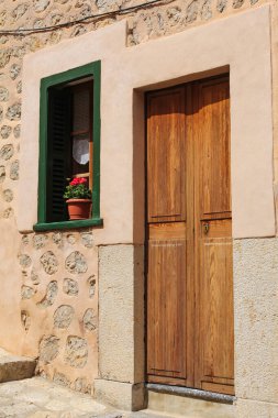 picturesque window decorated with flower and wooden door in mediterranean style
