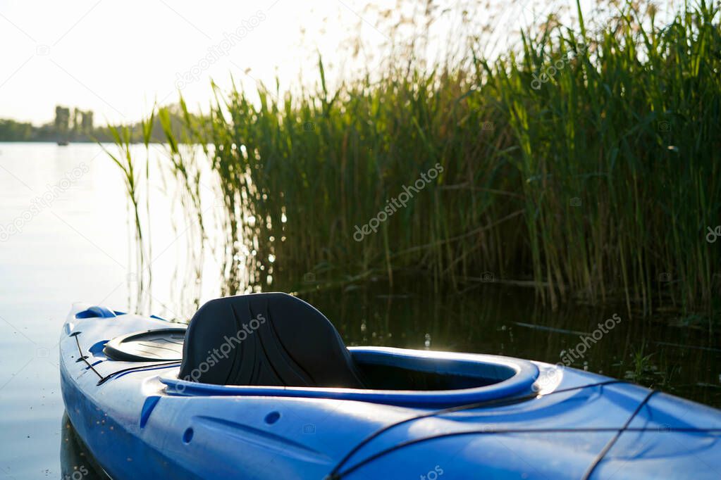 kayak on the lake near reeds during sunset