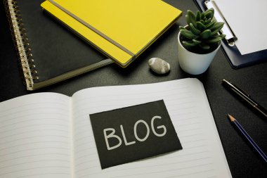 blog written on black paper card on open notebook