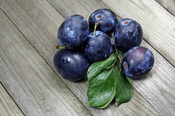 Fresh plums on wooden table — Stock Photo, Image