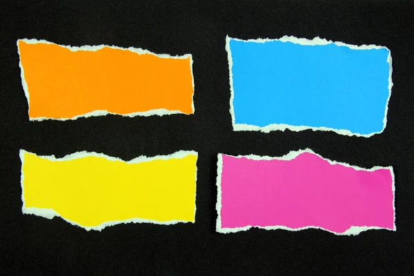 Colorful torn paper on black paper background — Stock Photo, Image