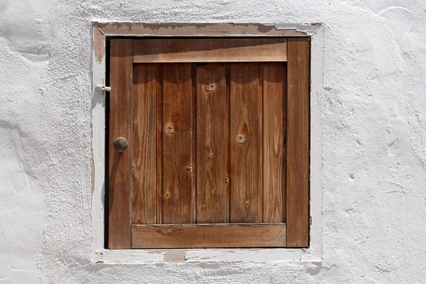 Vintage wooden shutter in whitewashed wall — Stock Photo, Image