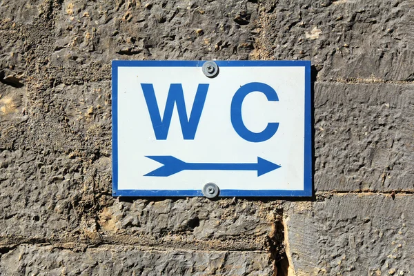 Segno di toilette su vecchio muro di pietra — Foto Stock