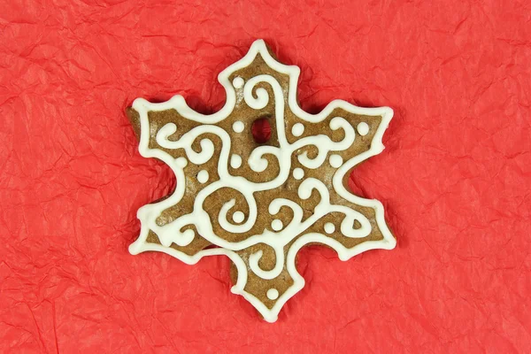 Christmas snowflake shape gingerbread on red background — Stock Photo, Image