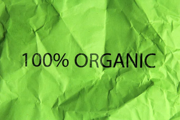 100 organic text on crumpled green paper — Stock Photo, Image