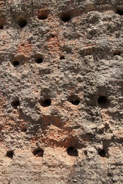 Ancient stone wall with holes — Stock Photo, Image