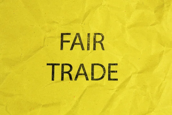 Fair trade text on yellow crumpled paper — Stock Photo, Image