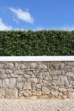 Eski taş duvar, çit ve mavi gökyüzü