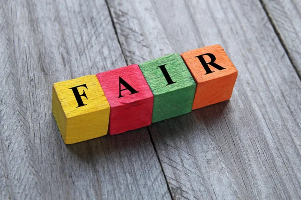 Word fair on colorful wooden cubes — Stok fotoğraf