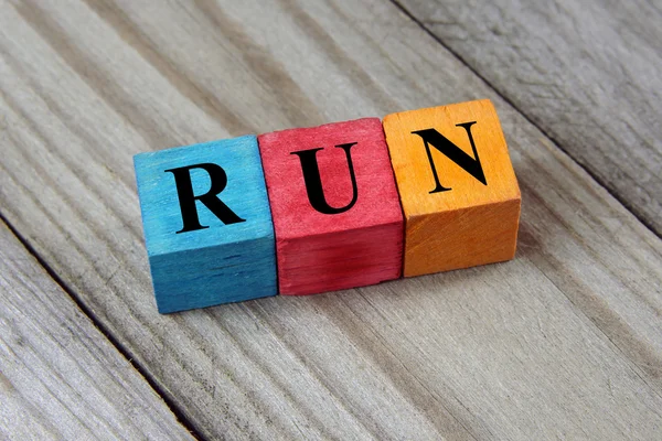 Word run on colorful wooden cubes — Stok fotoğraf