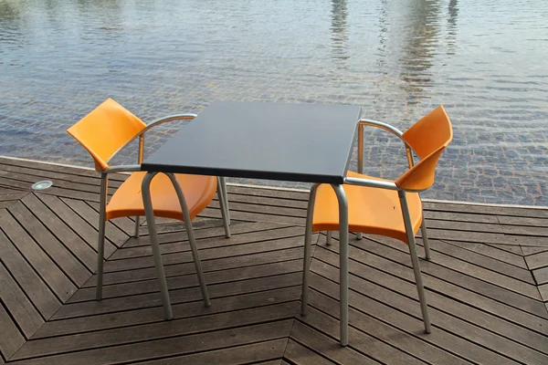 Zwei Stühle und Tisch in leerem Restaurant am Wasser — Stockfoto