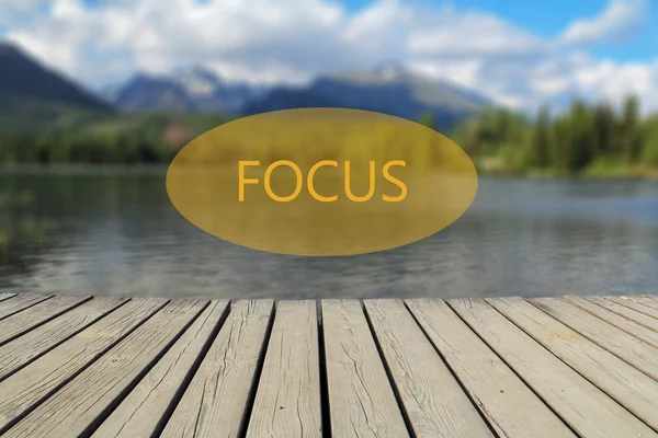 Focus text, mountain lake in the background — Stock Photo, Image
