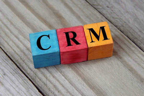 CRM texto (Gestión de relaciones con el cliente) en cubos de madera de colores — Foto de Stock