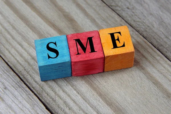 Texto PME (Pequenas e Médias Empresas) sobre cubos de madeira coloridos — Fotografia de Stock