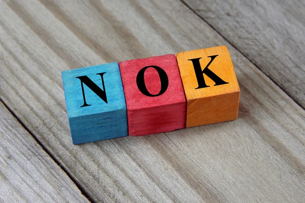 Nok (norwegische Krone) Zeichen auf bunten Holzwürfeln — Stockfoto