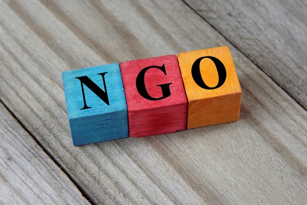 ONG (Organização Não Governamental) assina no cubo de madeira colorido — Fotografia de Stock
