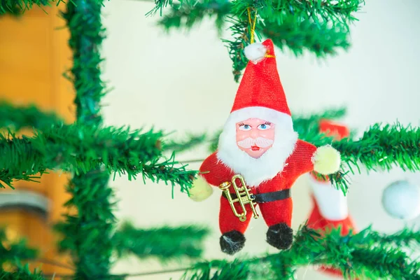 Cute santa claus toy hanging on tree, christmas background, decoration, celebration, greetings, copy space.