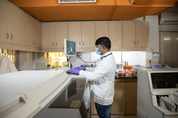 Erkek doktor hastanede gelişmiş tarama makinesi kullanıyor. Modern tıbbi ekipman üzerinde çalışan bir pratisyen. Dijital tanı, kalp hastalığı konsepti.