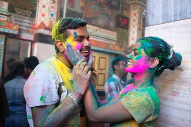 Jodhpur, Rajastha, Hindistan - 20 Mart 2020: Holi festivalini kutlayan mutlu Hintli çift, yüzü renkli pudrayla kaplanmış.