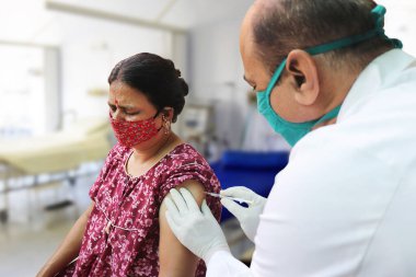 Hindistan 'da aşı, tıp çalışanı ya da doktor Coronavirus ya da Cvid-19' dan korumak için hastanede olgun bir kadına aşı yapıyor. COVISHIELD / COVAXIN Dose.