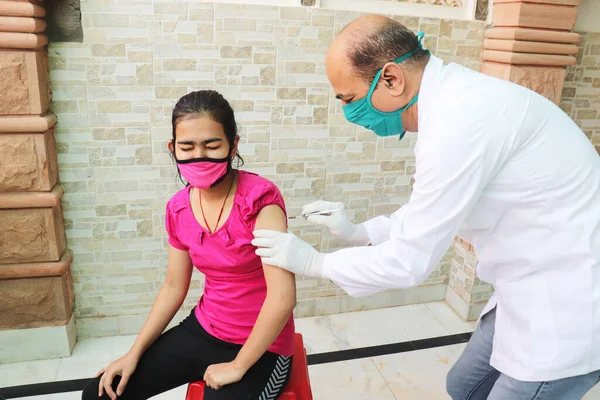 Hindistan 'da aşı, tıp çalışanı ya da doktor Coronavirus ya da Cvid-19' dan korumak için hastanede genç bir kıza aşı yapıyor. COVISHIELD / COVAXIN Dose.