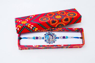 Güzel mavi elmas tasarımı Rakhi ve hediye kutusu beyaz arka planda kutlanır. Raksha Bandhan festivali Hindistan 'da erkek ve kız kardeş arasındaki sevgi ve bağı ifade etmek için kutlanır. Geleneksel Hint bilekliği