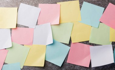 Beton duvar arkaplanı üzerine çok sayıda boş renkli kağıt yapıştırma listesi, iş anımsatıcı bellek post-it notları bugün çalışma kavramı