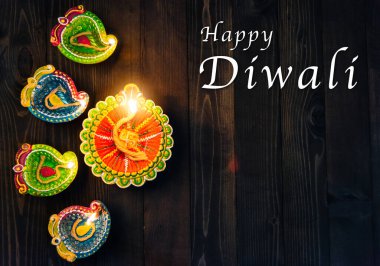 Üst tepedeki kil Diya ya da petrol lambası için ateş yakıyor, stüdyo siyah ahşap arka planda çekiliyor, Hinduizm Rangoli Dekorasyonu, Mutlu bayramlar Deepavali ya da Diwali festivali konsepti