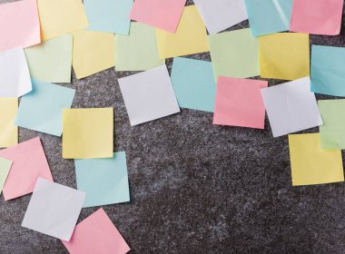 Beton duvar arkaplanı üzerine çok sayıda boş renkli kağıt yapıştırma listesi, iş anımsatıcı bellek post-it notları bugün çalışma kavramı