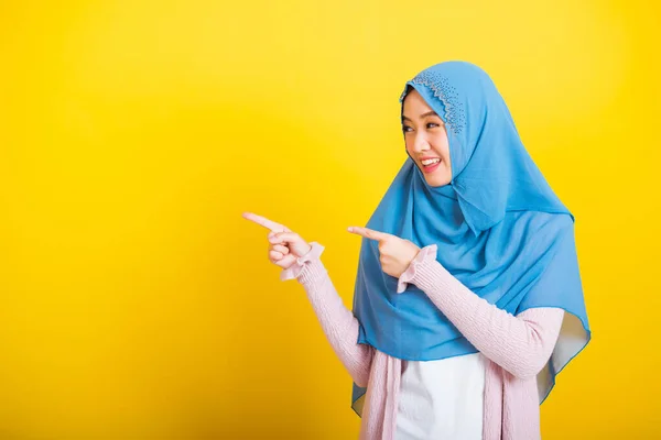 アジア系イスラム教徒アラブ人 幸せな美しい若い女性の肖像イスラム教の宗教的な摩耗ベールヒジャーブ面白い笑顔彼女は肯定的な表現は スペースに横に孤立黄色の背景に指側を指す — ストック写真