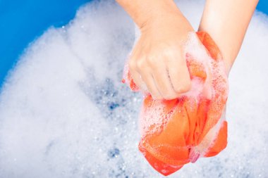 Yakın çekimde genç Asyalı kadın leğende çamaşır suyu, sabunlu köpük suyu, stüdyo çekimi arka planı, çamaşır konsepti...