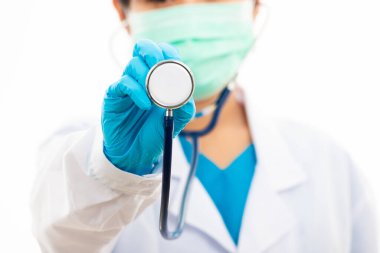 Kadın hemşire lastik eldiven takıyor ve tıbbi maske takıyor, beyaz üniformalı kadın doktor steteskop tutuyor ve kameraya gösteriyor, beyaz arka planda izole edilmiş, tıbbi sağlık konsepti