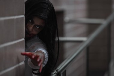 Evdeki karanlık bir odada korkunç kötü kadın hayaleti. Kan içindeki dişi zombi korkunçtur. Terk edilmiş binaya musallat oldu. Mutlu Cadılar Bayramı festivali konsepti.