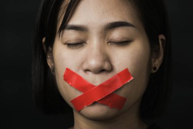 Asyalı bir kadın siyah arka planda kırmızı bantla gözlerini bağlıyor. Konuşma özgürlüğü sansürü ve konuşmayı durdurmak, Uluslararası İnsan Hakları Günü