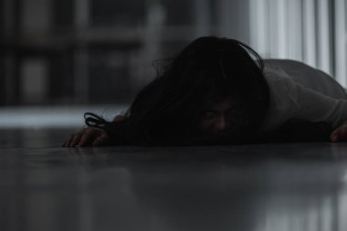 Korkunç kötü kadın hayalet, evdeki karanlık bir odada ölü yatıyor. Kan içindeki dişi zombi korkunçtur. Terk edilmiş binaya musallat oldu. Mutlu Cadılar Bayramı festivali konsepti.