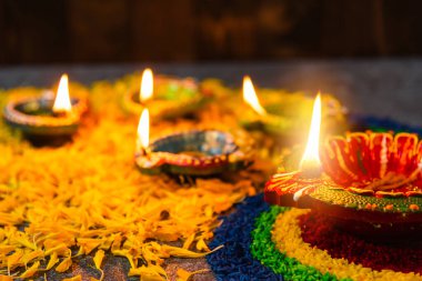 Çamuru kapat Diya 'ya ateş yak ya da arka planda çiçek olan gaz lambası, Hinduizm Rangoli Dekorasyonu, Mutlu bayramlar Deepavali, ya da Diwali Hint festivali konsepti