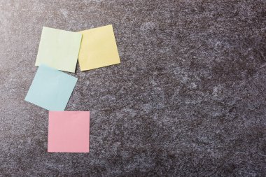 Beton duvar arkaplanı üzerine çok sayıda boş renkli kağıt yapıştırma listesi, iş anımsatıcı bellek post-it notları bugün çalışma kavramı