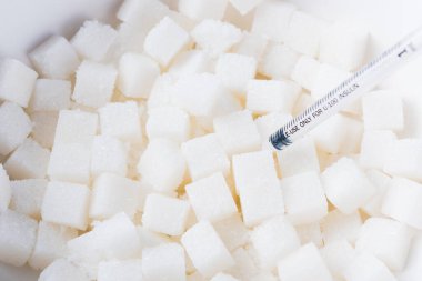 Şeker kübü dokusu tatlı gıda malzemesi ve şırınga, stüdyo çekim sağlık yüksek kan riski diyabet ve kalori alımı kavramı