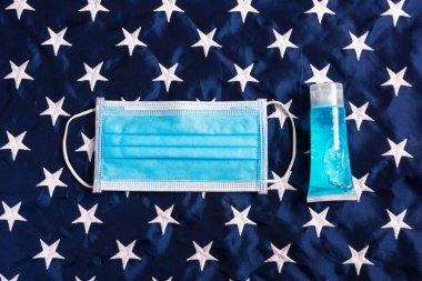 Mavi Amerika yıldızının arka planı, stüdyo çekimi, sağlık sigortası, Coronavirus veya Covid-19 'u engellemek için tıbbi koruyucu tek kullanımlık yüz maskesi.