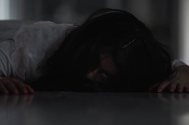 Korkunç kötü kadın hayalet, evdeki karanlık bir odada ölü yatıyor. Kan içindeki dişi zombi korkunçtur. Terk edilmiş binaya musallat oldu. Mutlu Cadılar Bayramı festivali konsepti.