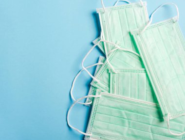 Ağız ve burun için tıbbi yeşil koruyucu yüz maskesi, mavi arka planda izole edilmiş stüdyo çekimi, güvenlik sağlık hizmetleri Coronavirus 'u engeller.