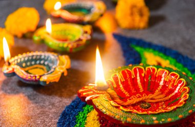 Çamuru kapat Diya 'ya ateş yak ya da arka planda çiçek olan gaz lambası, Hinduizm Rangoli Dekorasyonu, Mutlu bayramlar Deepavali, ya da Diwali Hint festivali konsepti