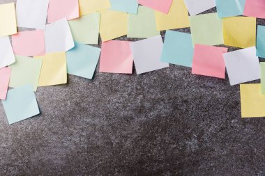 Beton duvar arkaplanı üzerine çok sayıda boş renkli kağıt yapıştırma listesi, iş anımsatıcı bellek post-it notları bugün çalışma kavramı