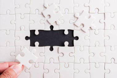 Top view düz konum son parça beyaz kağıt yapboz oyunu çözülmesi için yerleştirilen son parçalar tam bir görev, stüdyo çekimi siyah arka plan, quiz hesaplama konsepti