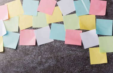 Beton duvar arkaplanı üzerine çok sayıda boş renkli kağıt yapıştırma listesi, iş anımsatıcı bellek post-it notları bugün çalışma kavramı