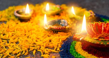 Çamuru kapat Diya 'ya ateş yak ya da arka planda çiçek olan gaz lambası, Hinduizm Rangoli Dekorasyonu, Mutlu bayramlar Deepavali, ya da Diwali Hint festivali konsepti