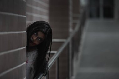 Evdeki karanlık bir odada korkunç kötü kadın hayaleti. Kan içindeki dişi zombi korkunçtur. Terk edilmiş binaya musallat oldu. Mutlu Cadılar Bayramı festivali konsepti.