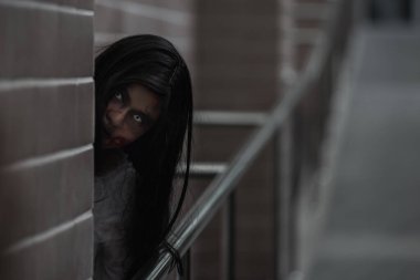 Evdeki karanlık bir odada korkunç kötü kadın hayaleti. Kan içindeki dişi zombi korkunçtur. Terk edilmiş binaya musallat oldu. Mutlu Cadılar Bayramı festivali konsepti.