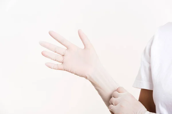 医師のための白いゴムラテックス外科用医療手袋を身に着けていると手を置く女性 白の背景に隔離されたスタジオショット 病院の感染制御コンセプト — ストック写真